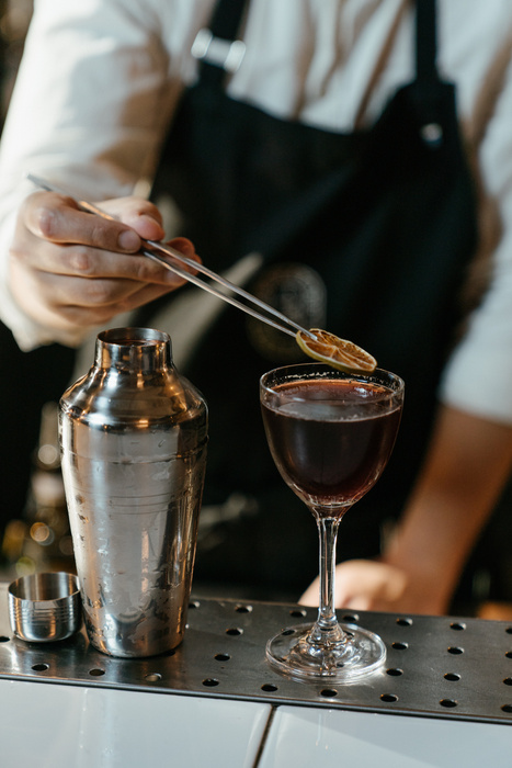 Person Pouring Brown Liquid on Clear Drinking Glass